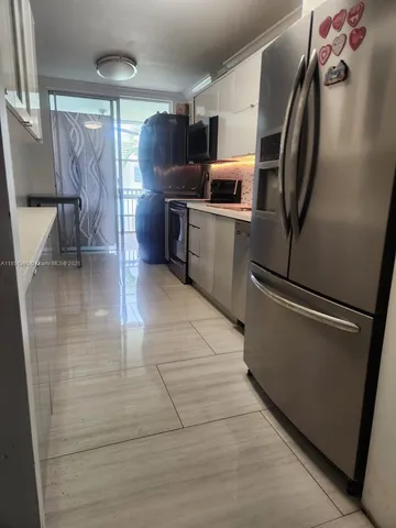 a kitchen with granite countertop a refrigerator and a sink