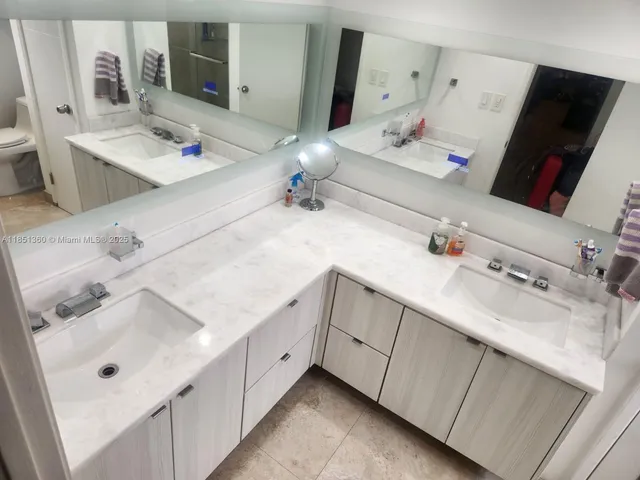 a bathroom with double vanity sink and a mirror
