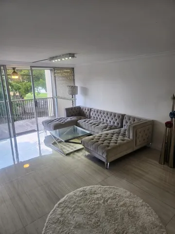 a living room with furniture and a floor to ceiling window
