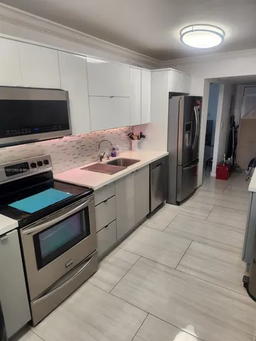 a kitchen with stainless steel appliances a stove a microwave and a sink