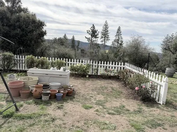 a view of a yard with furniture and wooden fence