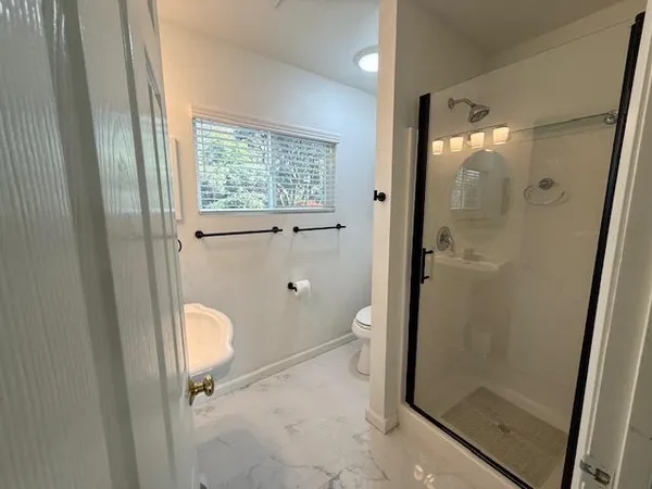 a bathroom with a granite countertop sink a mirror and a shower