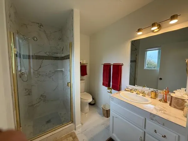 a bathroom with a granite countertop sink mirror and shower
