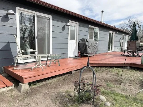 a view of backyard with deck and outdoor seating