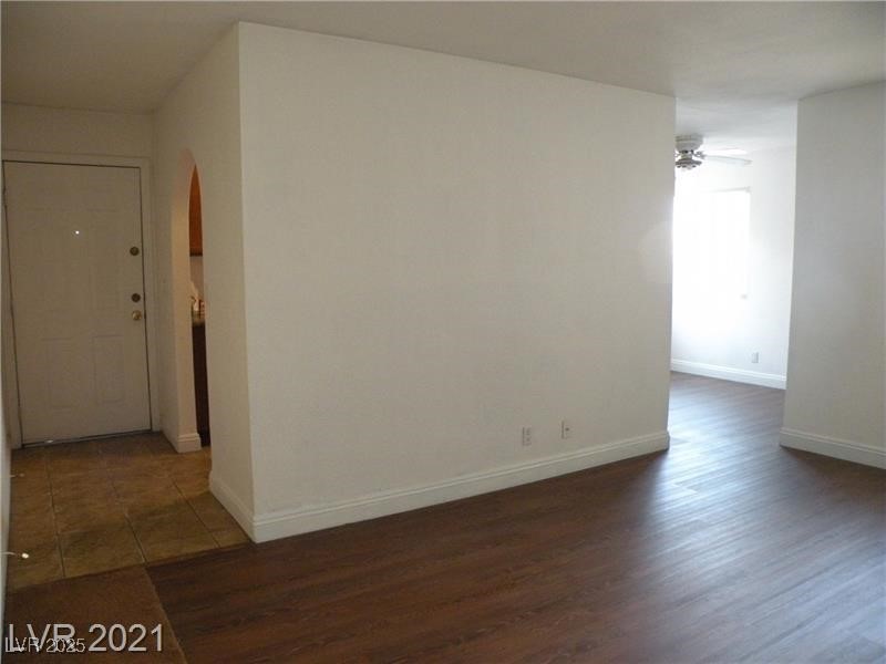 1844 North Decatur Boulevard, Unit 103 Las Vegas, NV 89108 - Photo 3 of 9 Spare room with dark wood-type flooring, arched walkways, and a ceiling fan