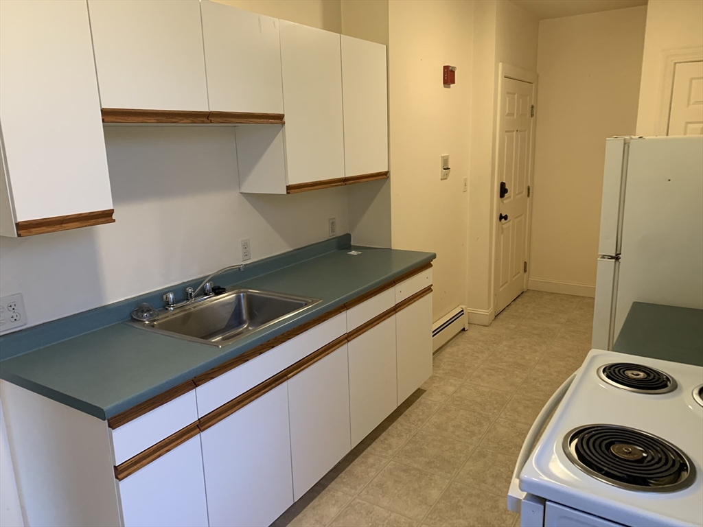 356 East Merrimack Street, Unit 5 Lowell, MA 01852 - Photo 1 of 8 a kitchen with stainless steel appliances granite countertop a sink and a stove