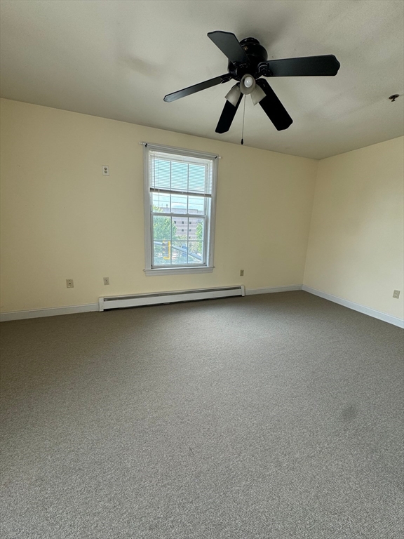 356 East Merrimack Street, Unit 5 Lowell, MA 01852 - Photo 4 of 8 an empty room with chandelier fan and windows