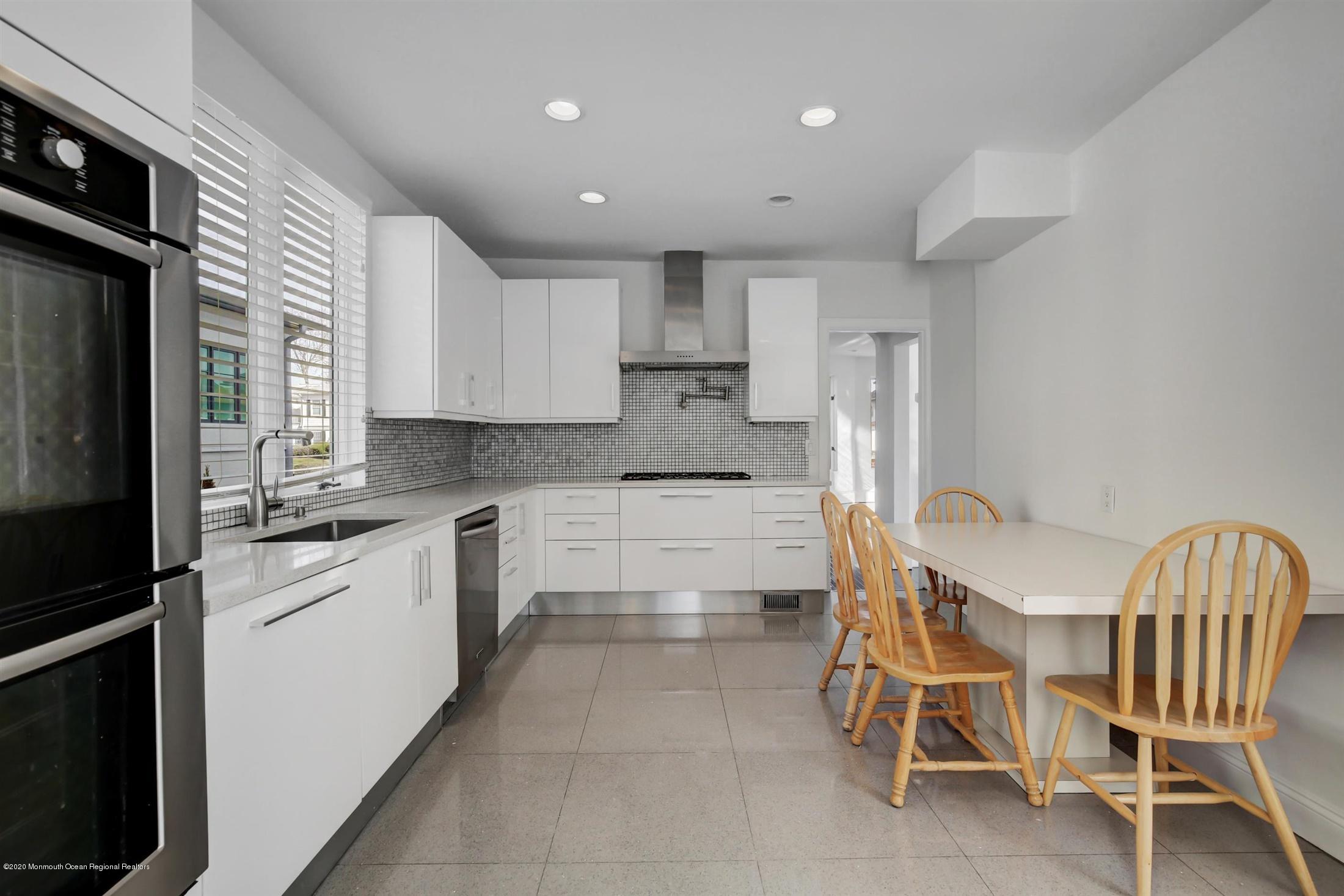 60 Monmouth Drive Deal, NJ 07723 - Photo 11 of 33 a kitchen with a table chairs microwave and cabinets