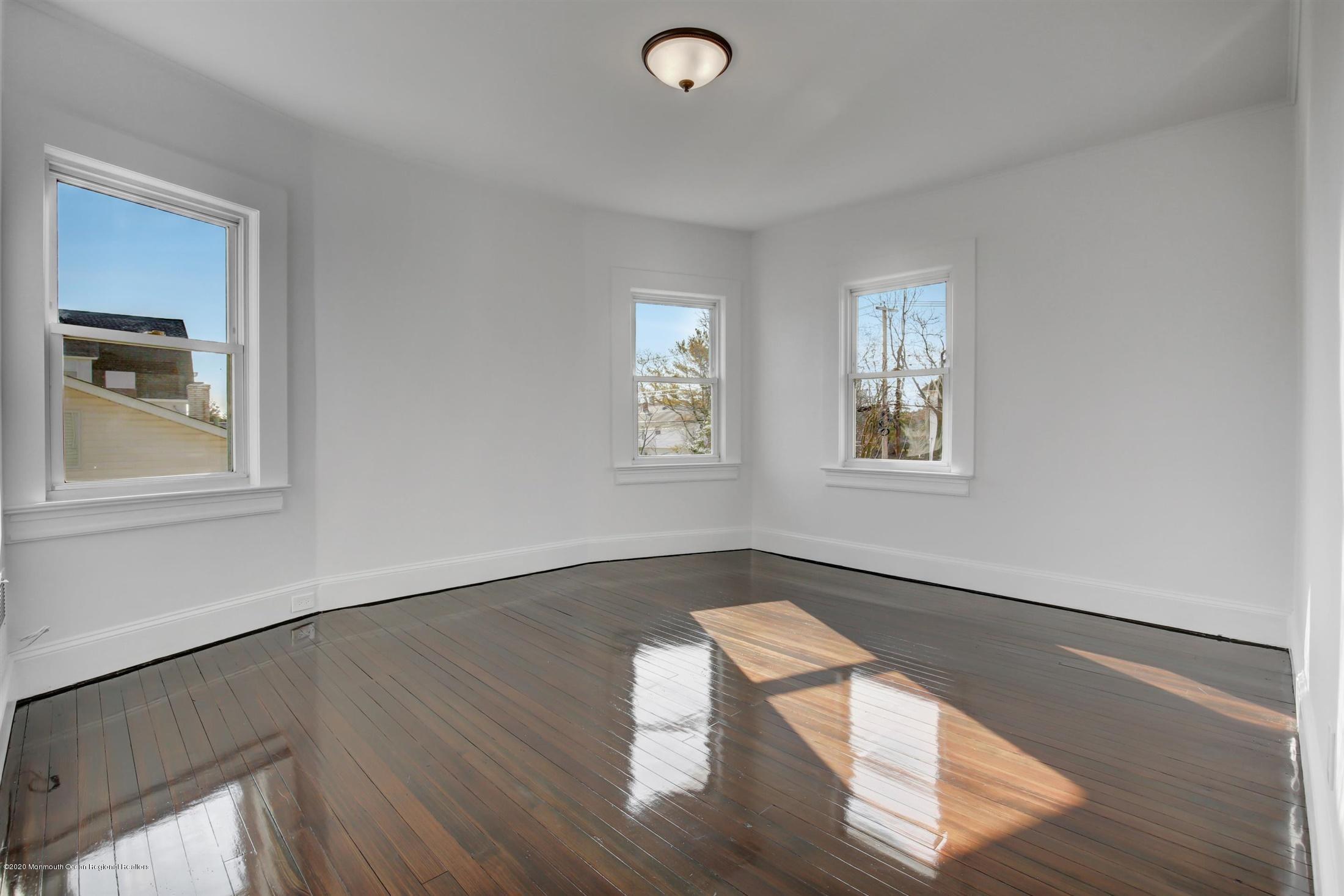 60 Monmouth Drive Deal, NJ 07723 - Photo 19 of 33 a view of an empty room with wooden floor and a window