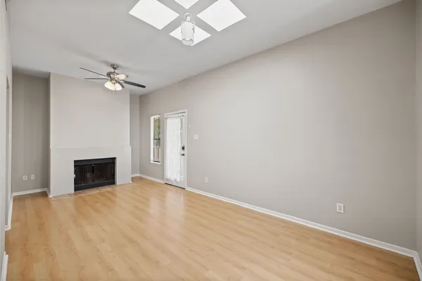 an empty room with a ceiling fan and a fireplace