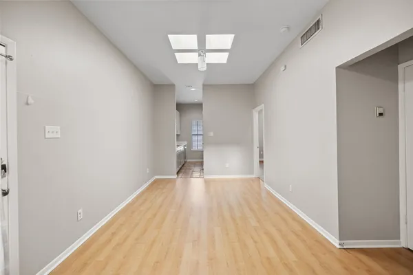 a view of empty room with wooden floor and window