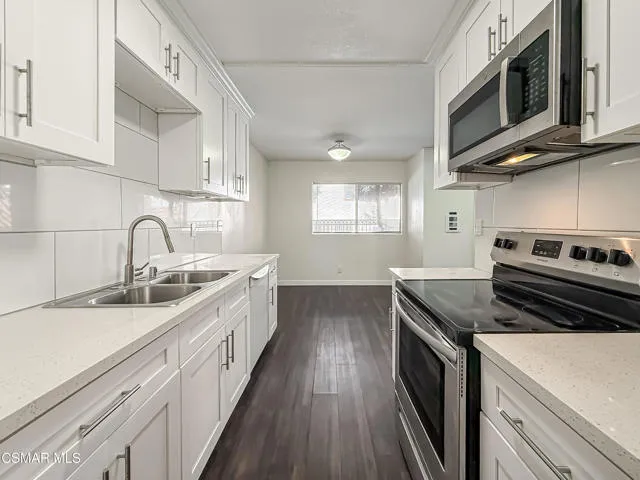 a kitchen with stainless steel appliances granite countertop a sink and stove top oven
