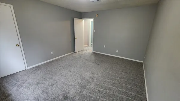an empty room with a chandelier fan