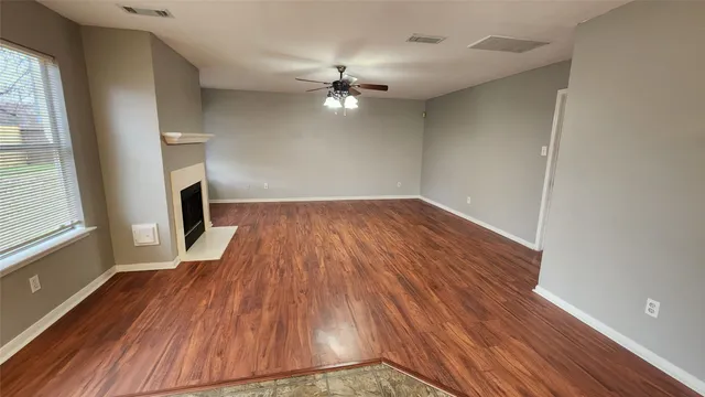wooden floor in an empty room with a window