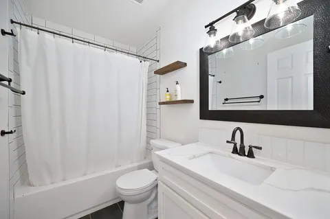 a bathroom with a sink a toilet and a mirror