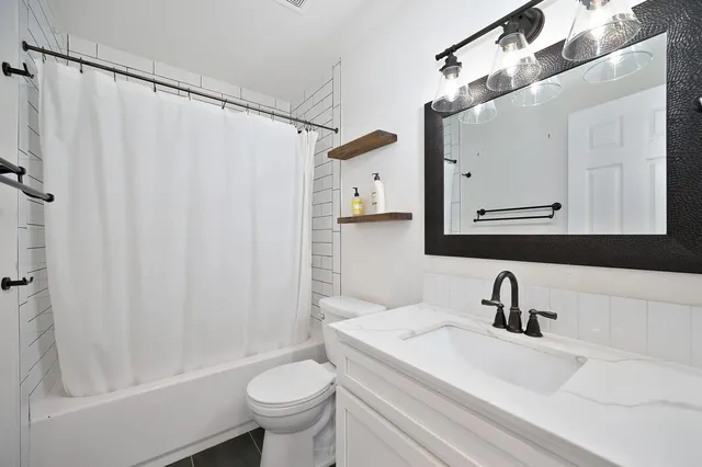 a bathroom with a sink a toilet and a mirror