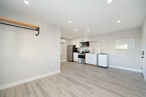 a kitchen with a refrigerator a stove top oven a sink and cabinets