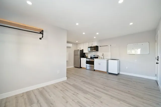 a kitchen with a refrigerator a stove top oven a sink and cabinets