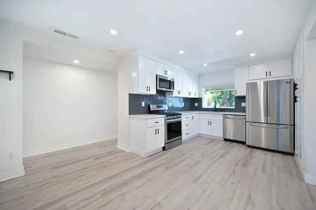 a kitchen with a refrigerator a sink and a stove top oven