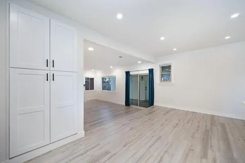a view of an empty room with wooden floor