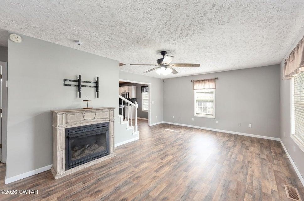 524 South Main Street Ridgely, TN 38080 - Photo 4 of 23 an empty room with windows a fireplace and wooden floor
