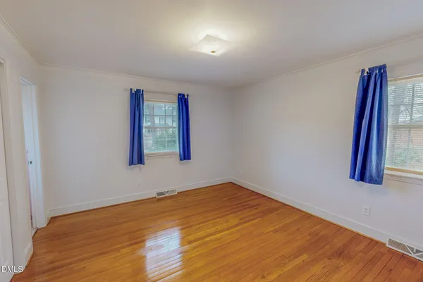 a view of an empty room with wooden floor