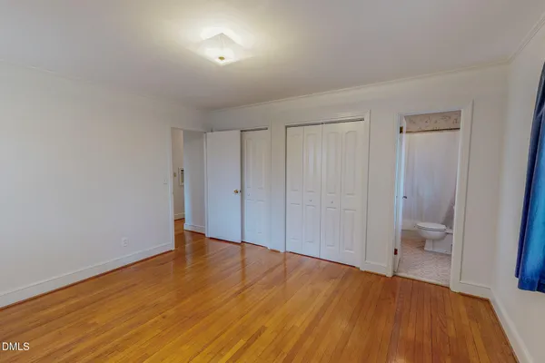 a view of a room with wooden floor and a bathroom