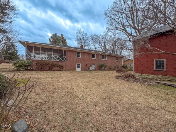 a backyard of a house with fire pit and trees