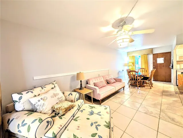a living room with furniture a dining table and a chandelier