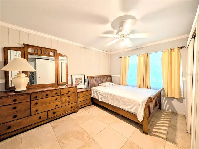 a spacious bedroom with a large bed and a chandelier
