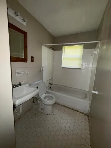 a bathroom with a toilet a sink and bathtub