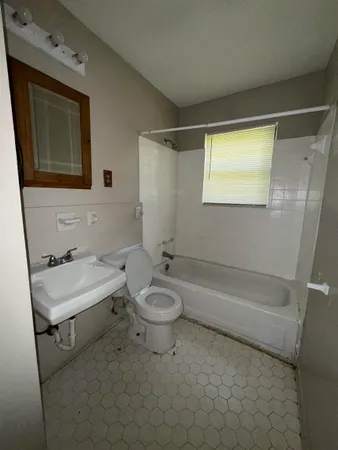 a bathroom with a granite countertop sink toilet a mirror and bathtub