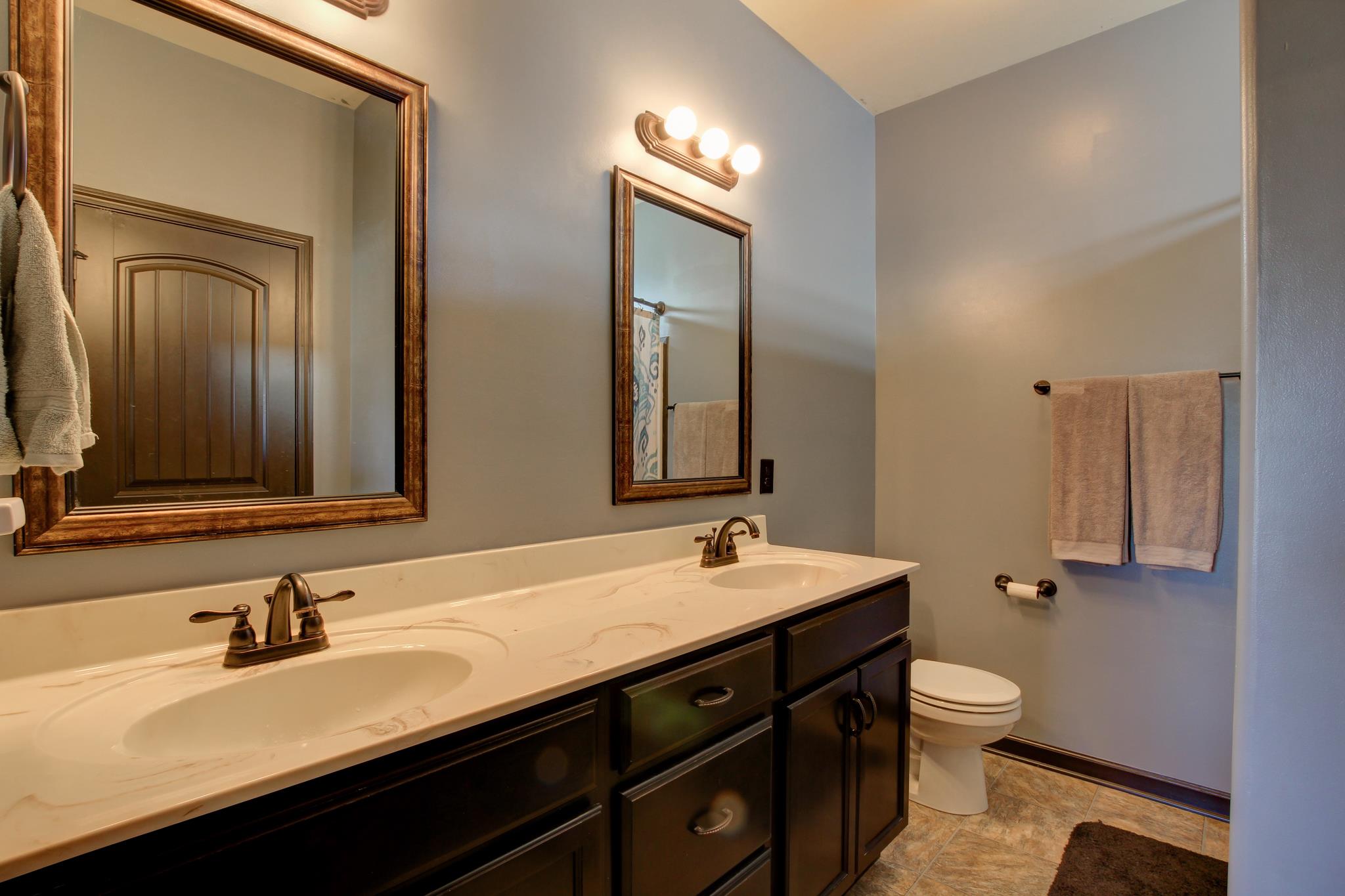 3736 Suiter Road Clarksville, TN 37040 - Photo 14 of 21 a bathroom with a double vanity sink toilet and mirror