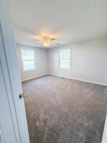 an empty room with windows and closet