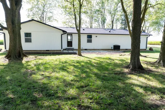a view of a house with backyard and tree