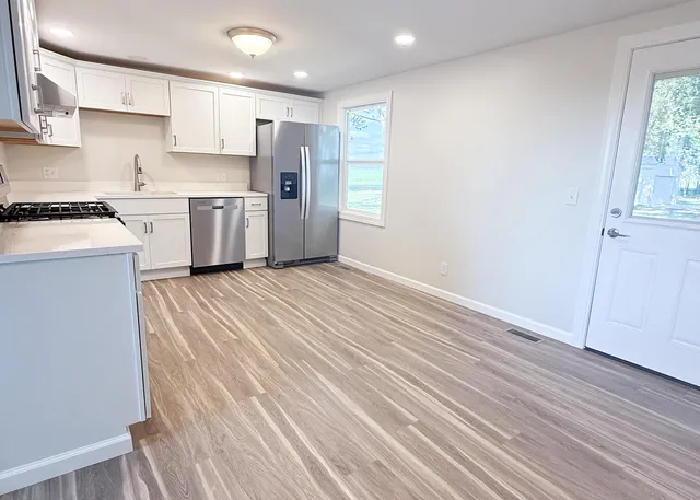 a view of a kitchen with wooden floor and electronic appliances