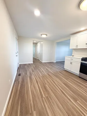 a view of a room with wooden floor and electronic appliances