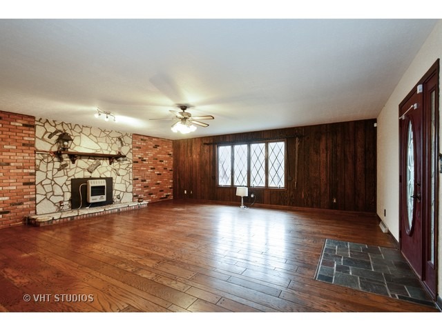 3239 East Bemes Road Crete, IL 60417 - Photo 2 of 10 an empty room with wooden floor fireplace and windows