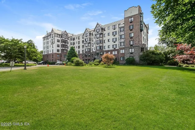 a large building with a big yard and large trees