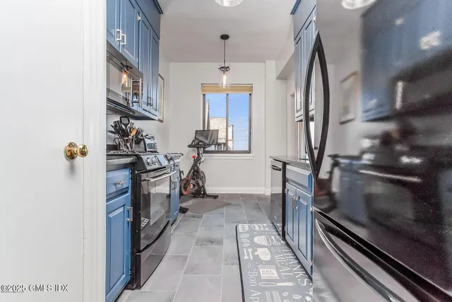 a kitchen with stainless steel appliances granite countertop a sink stove refrigerator and cabinets