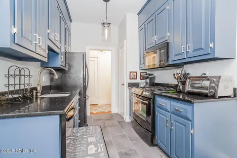 a kitchen with stainless steel appliances granite countertop a sink and cabinets