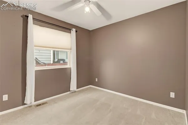 an empty room with a bathroom and a window