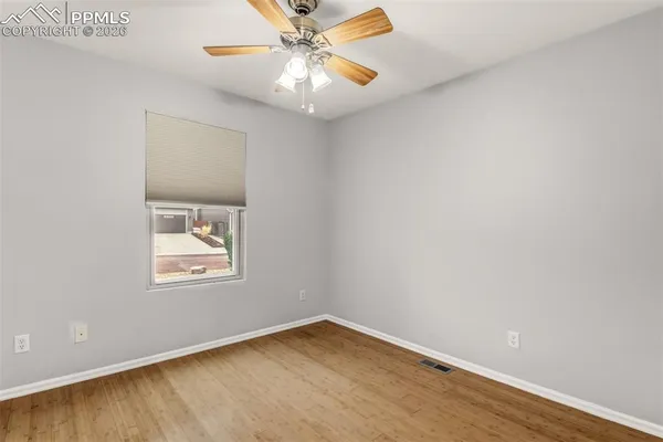 an empty room with a window and a fan