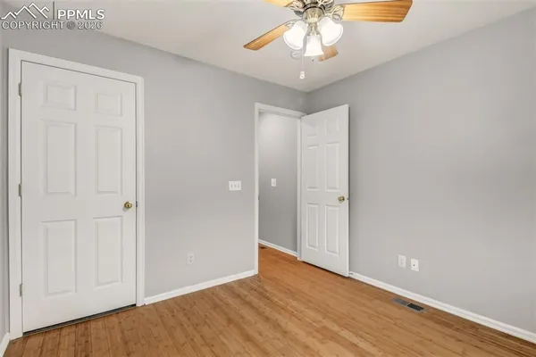 a view of an empty room with wooden floor