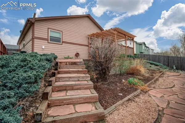 a view of a house with a yard and potted plants