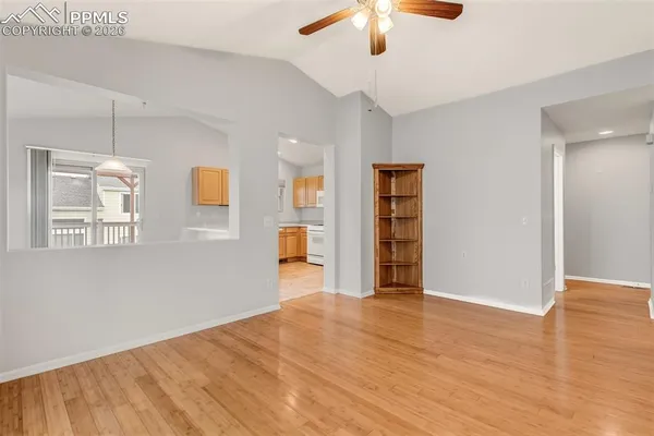 a view of an empty room with a window and wooden floor