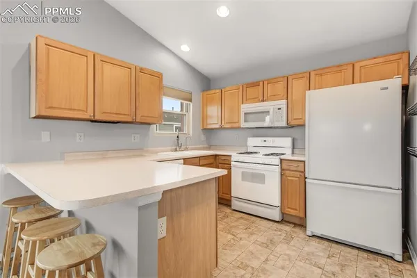 a kitchen with a white cabinets sink and a refrigerator