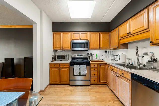 a kitchen with stainless steel appliances granite countertop a stove a sink and a microwave