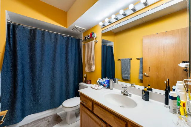 a bathroom with a sink a toilet and shower curtain