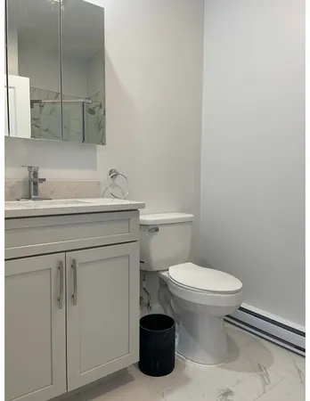 a bathroom with a sink toilet and a mirror